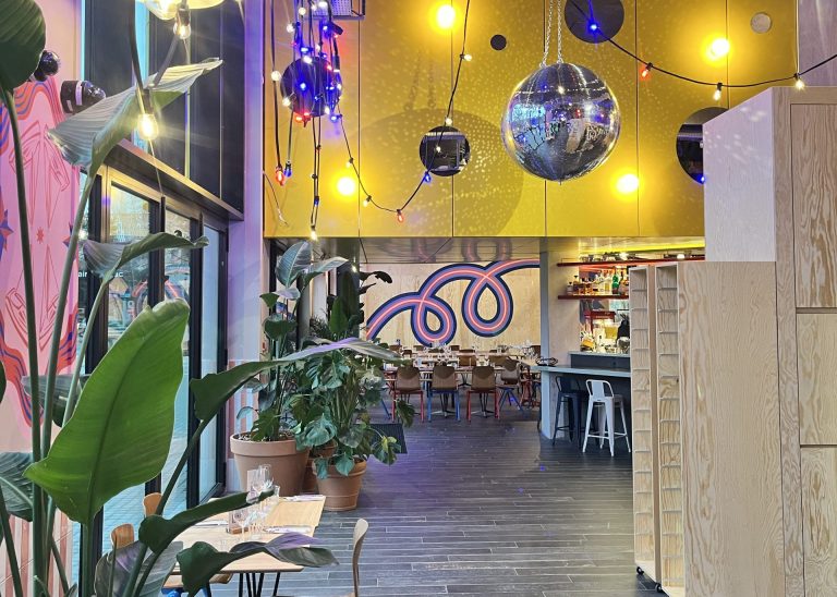 Allée de plantes vertes sous des guirlandes et des boules à facettes, menant au restaurant de l’EKLO Hôtel de Nantes, pour la soirée d’ELO Énergie
