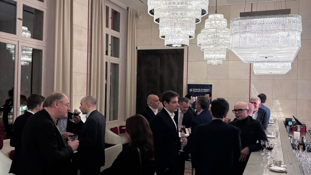 Invités échangeant un verre à la main sous les lustres en cristal de la Maison Baccarat, lors de la soirée corporate SSGA organisée par Weevup à Paris