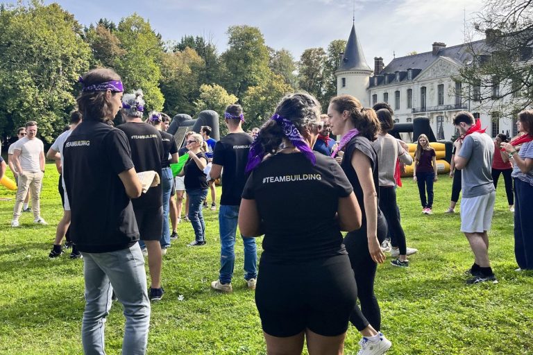 Olympiades dans le parc du Château d’Ermenonville, dans l’Oise : participants de CMI Stratégies en bandanas de couleur, structures gonflables et château en arrière-plan