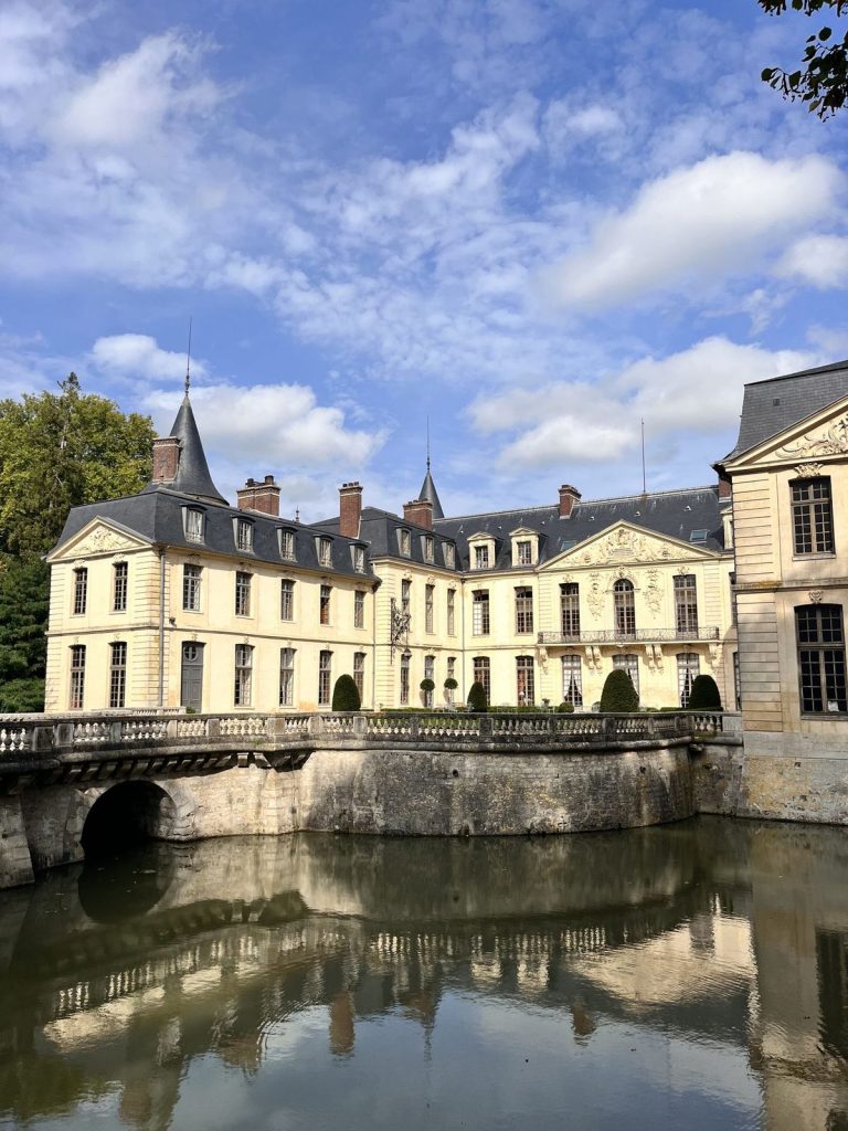 Façade du Château d’Ermenonville et ses douves sous un ciel bleu, lieu du séminaire de CMI Stratégies