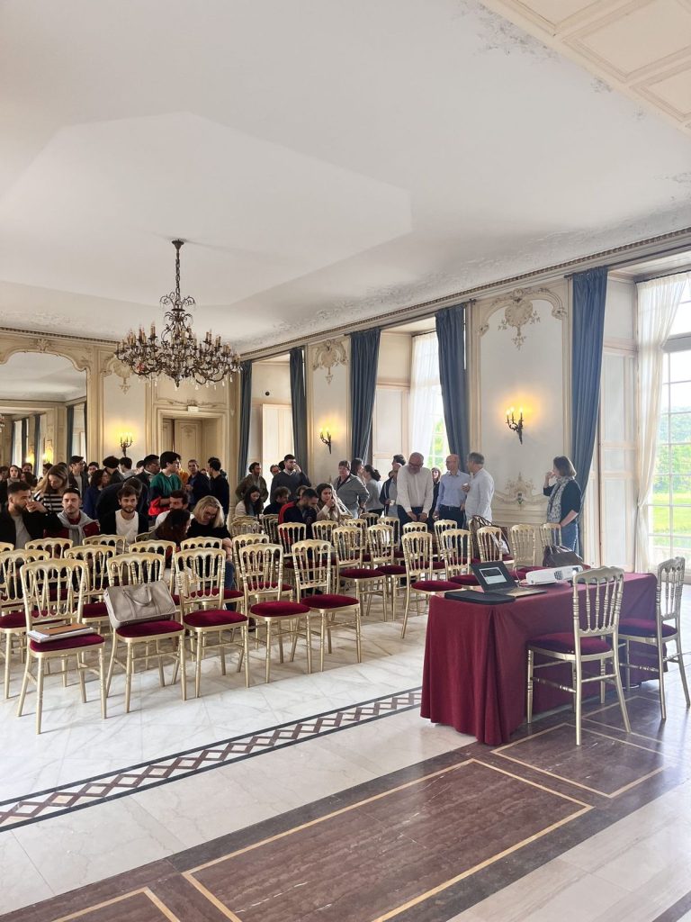 Salle de plénière du Château d’Ermenonville en configuration théâtre, chaises dorées et lustre, à l’arrivée des participants