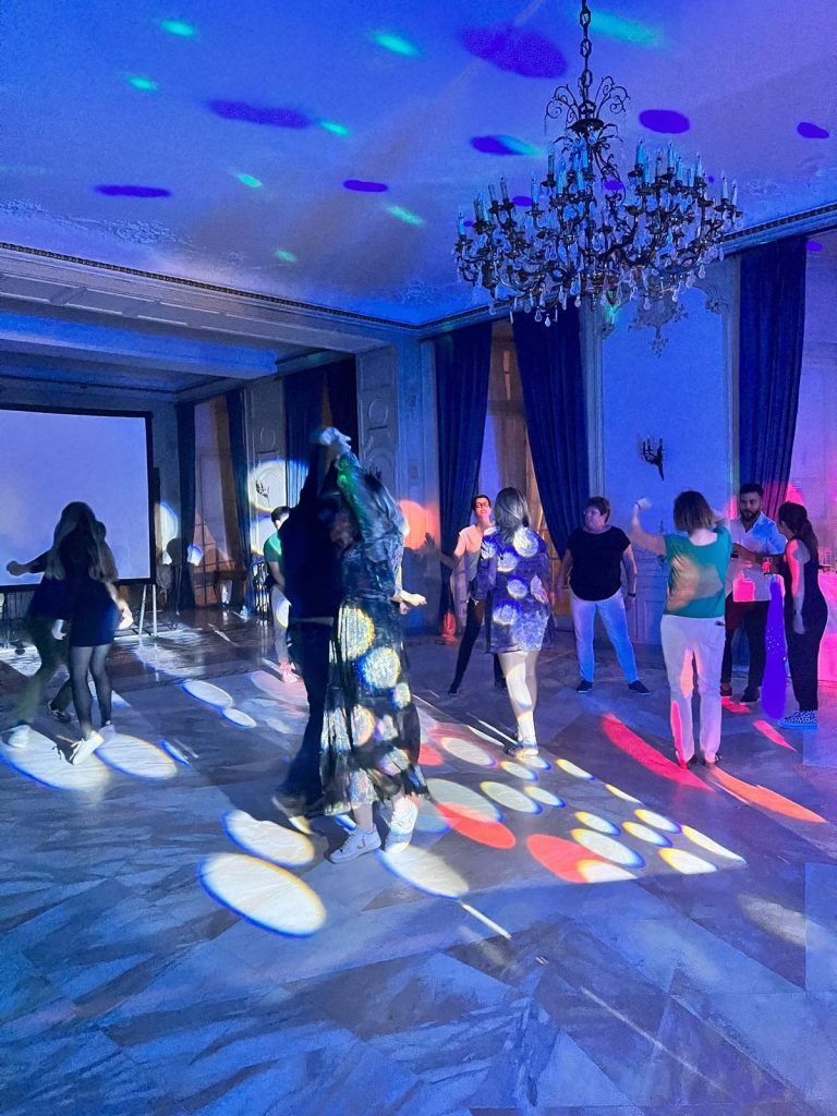 Soirée dansante dans la salle de plénière du Château d’Ermenonville, sous le lustre, avec des jeux de lumière colorés sur la piste