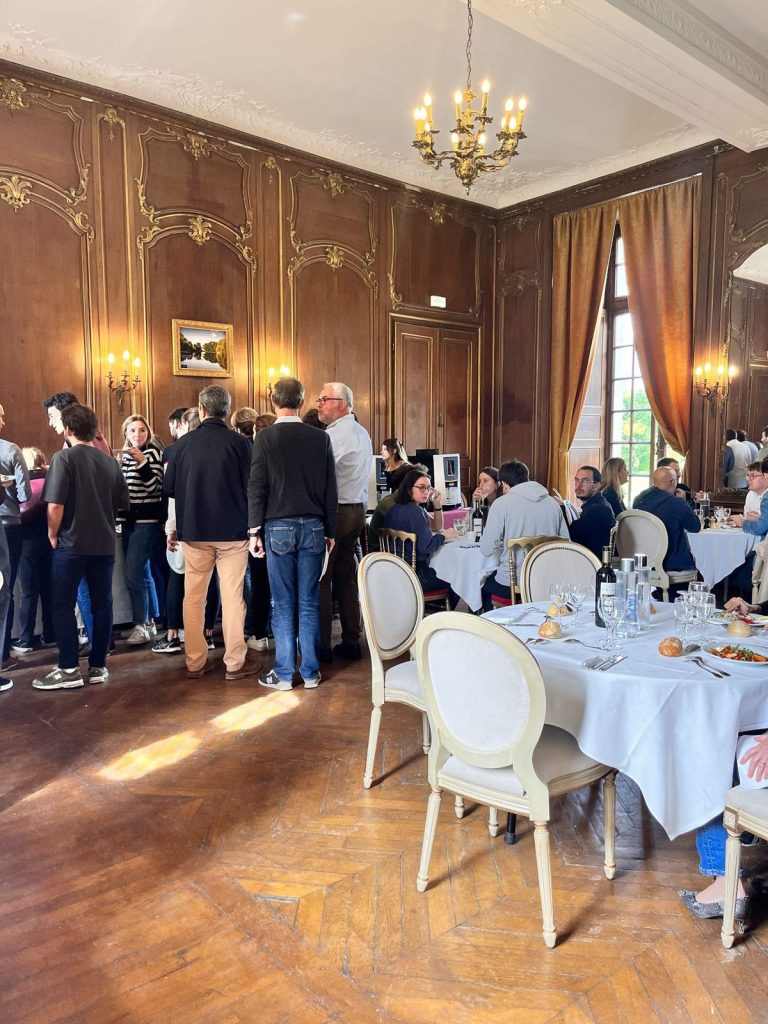 Brunch du vendredi dans un salon lambrissé du Château d’Ermenonville, participants au buffet et tables dressées