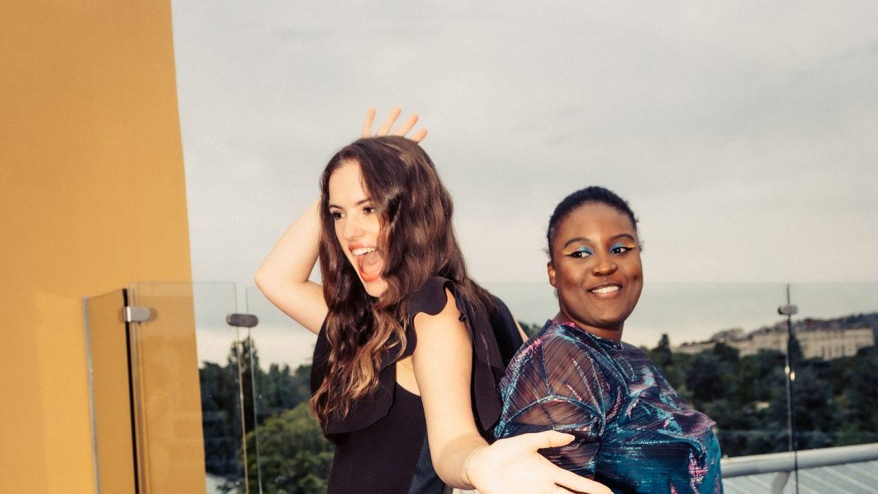 Deux invitées prennent la pose sur une plateforme photo, lors de la cocktail party Dior organisée par Weevup sur un rooftop
