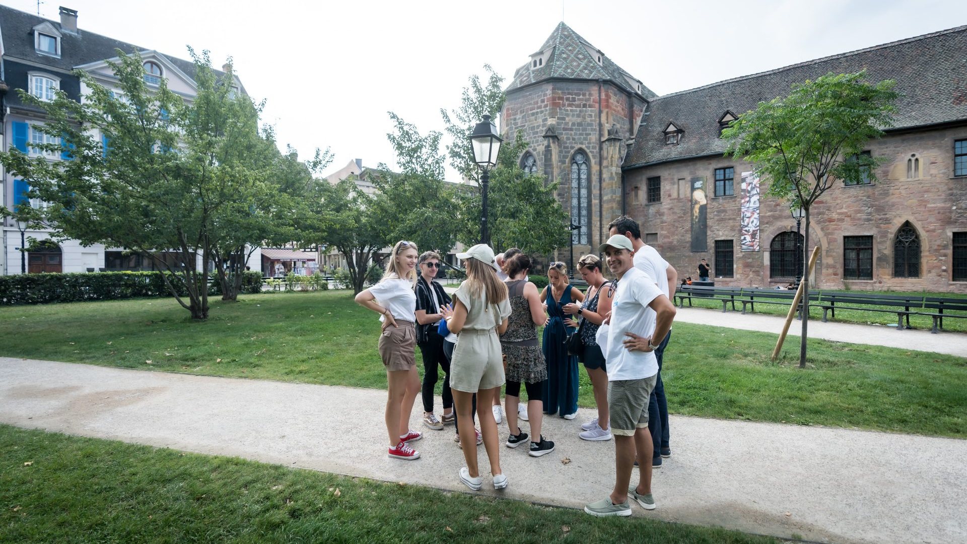 Petit groupe de participants du séminaire annuel d'Elanco, organisé par Weevup, réunis sur une allée de jardin devant un bâtiment ancien en pierre, en Alsace