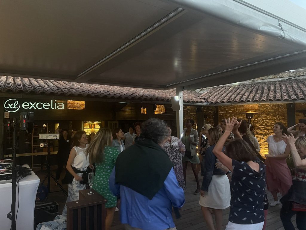 Soirée dansante des collaborateurs d’Excelia sous la terrasse couverte du Bastion, logo Excelia projeté sur le mur et platines du DJ à gauche