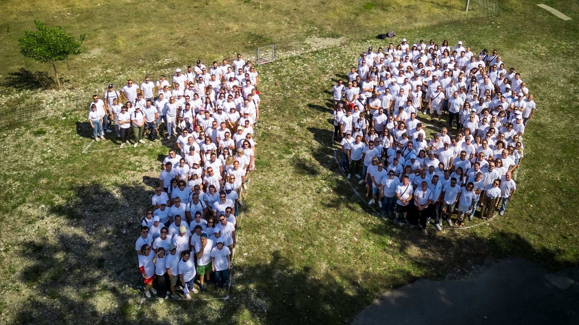 Vue aérienne des collaborateurs d'Elanco vêtus de blanc formant le nombre 70 sur une pelouse, pendant le séminaire annuel organisé par Weevup