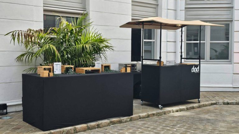 Stands du traiteur habillés de noir et décorés de plantes, dans la cour des bureaux de Coty, pour sa Summer Party