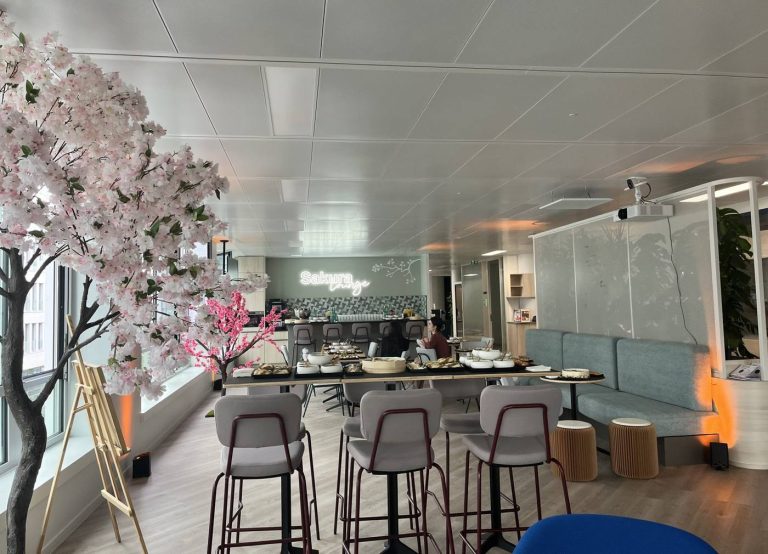 Espace cocktail « Sakura Lounge » des nouveaux locaux de Daiichi, décoré de cerisiers en fleurs, avec buffet et tables hautes, lors de l’inauguration organisée par Weevup