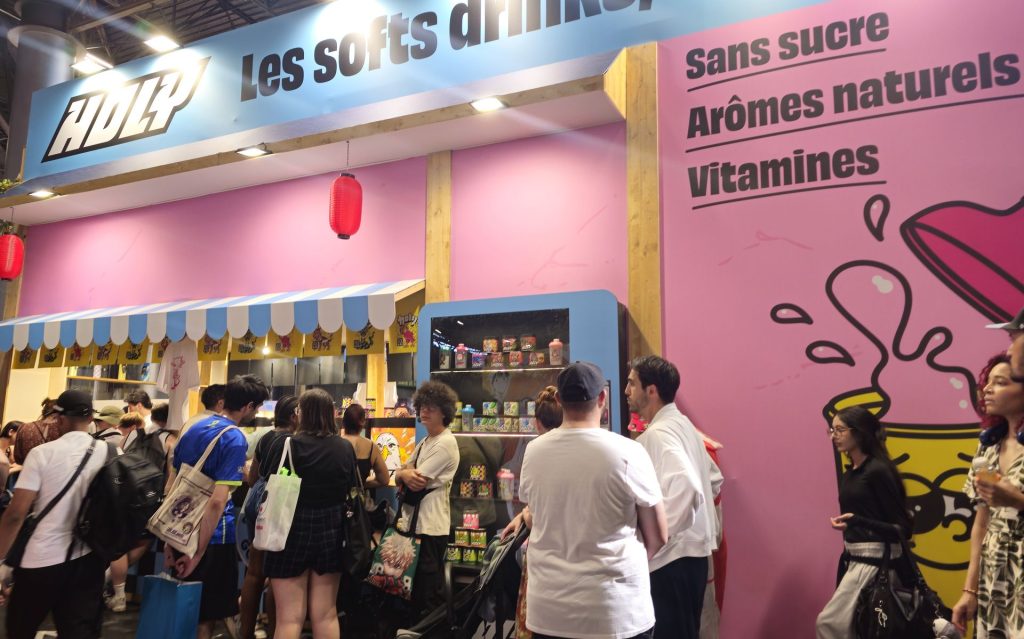 File de festivaliers au bar de dégustation Holy à Japan Expo, une visiteuse boisson en main