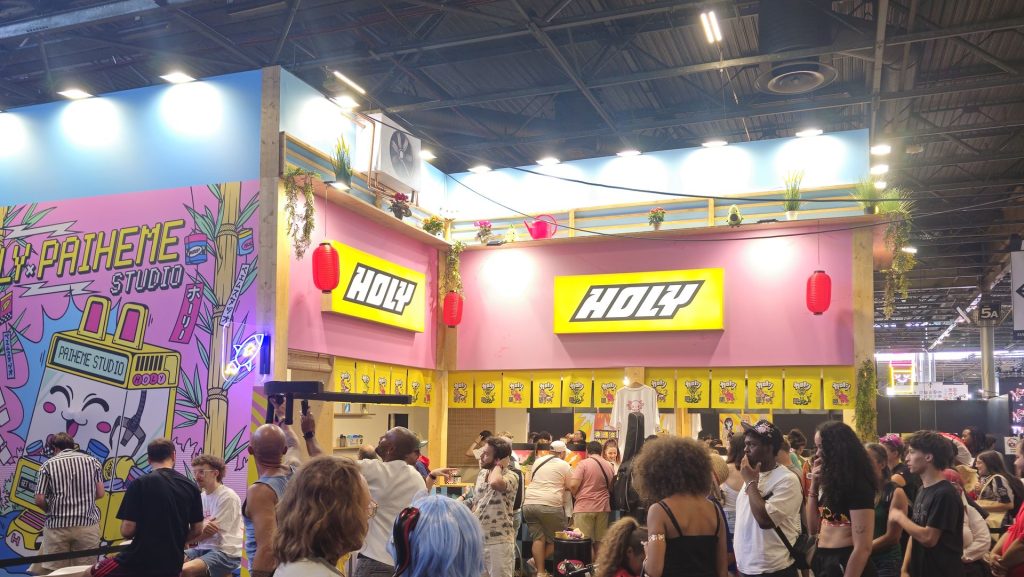 Stand Holy à la Japan Expo : enseignes jaunes, lanternes rouges et fresque colorée, foule devant le comptoir