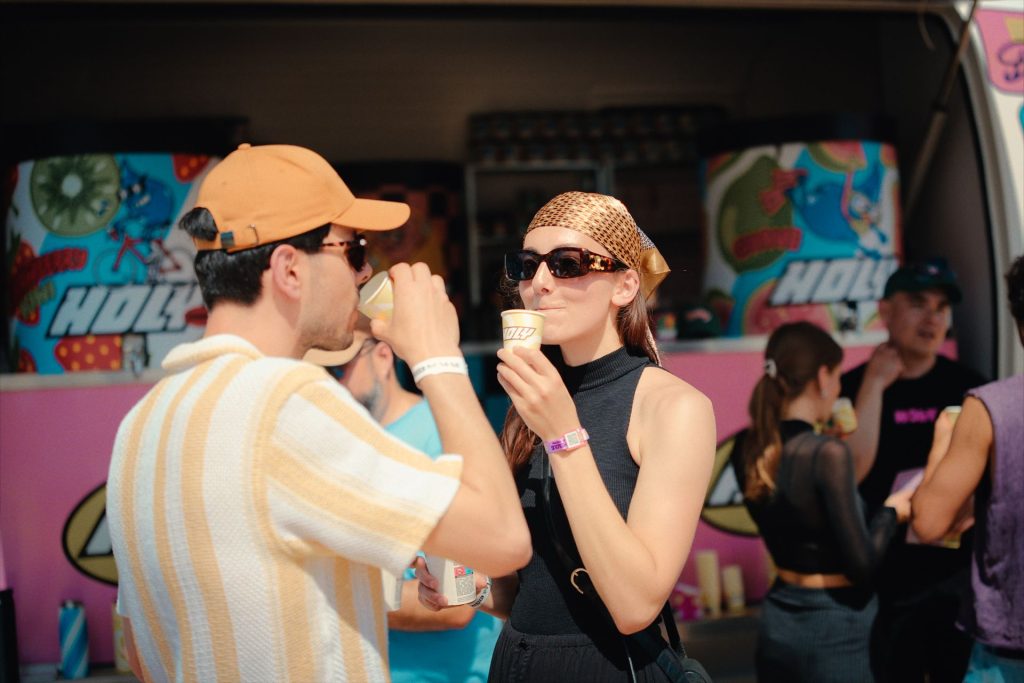 Festivaliers dégustant les boissons Holy devant le comptoir de la caravane-bar, au Marvellous Island Festival