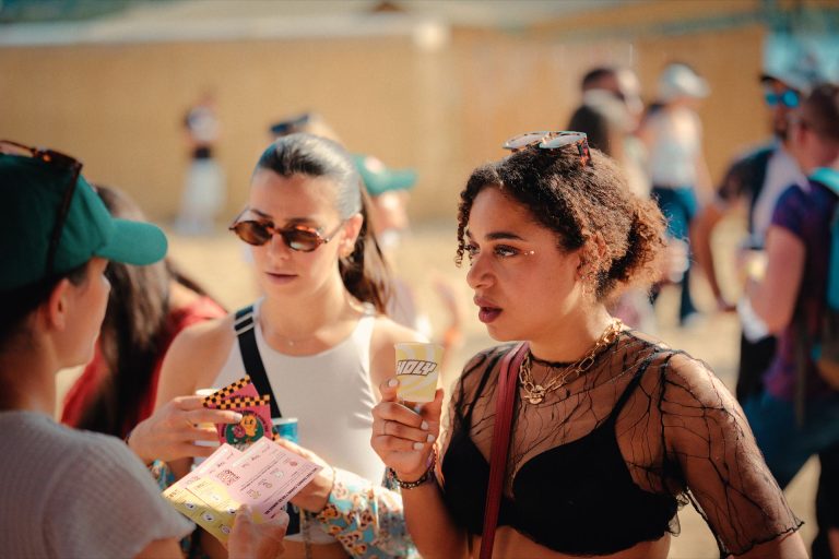 Festivalières, gobelet Holy en main, découvrant le jeu du stand au Marvellous Island Festival