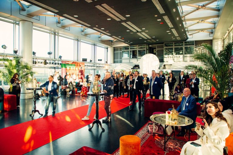 Invités de la soirée Interface à l’Institut du monde arabe, debout dans un décor oriental avec tapis rouge, lanternes, palmiers et poufs colorés