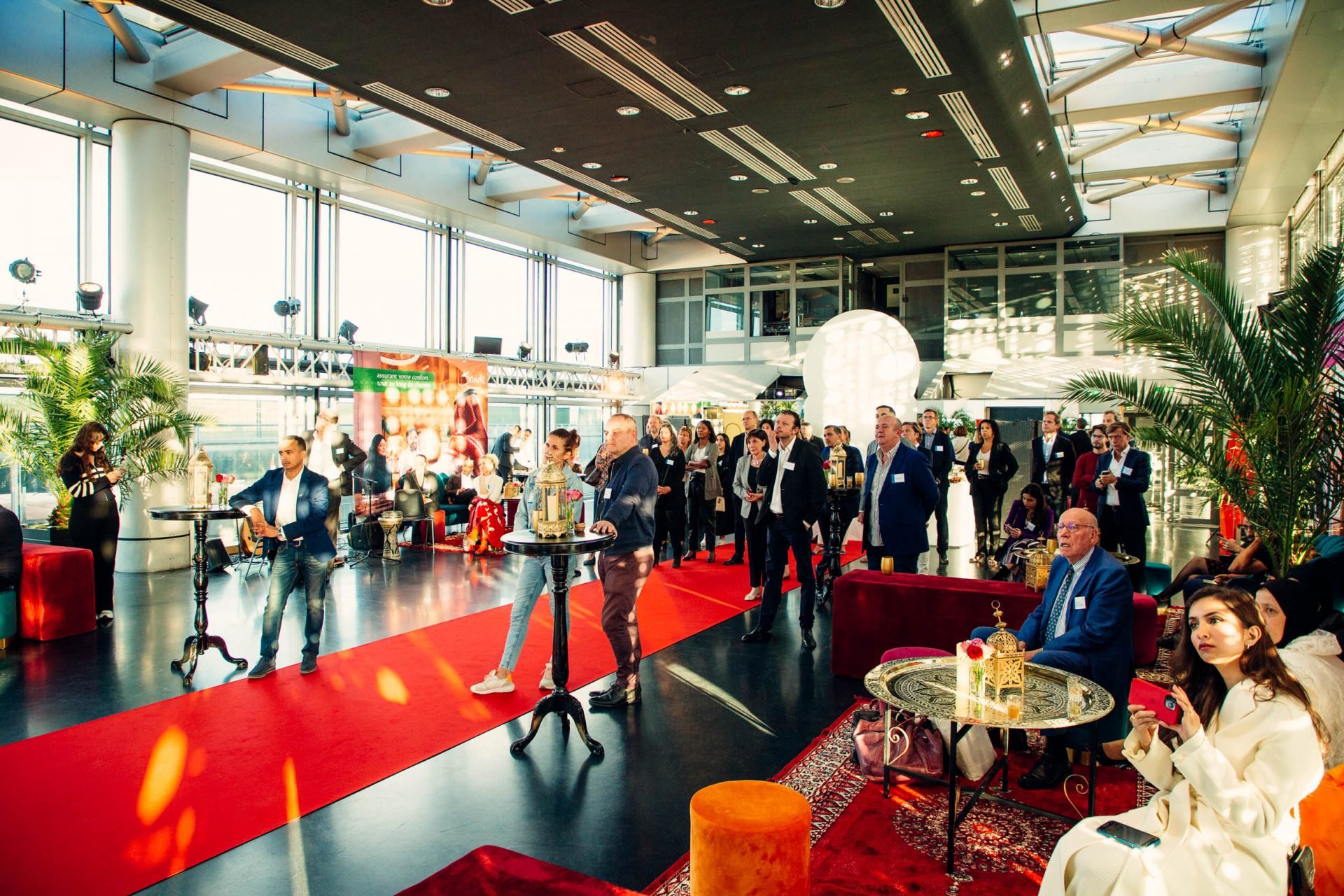 Invités de la soirée Interface à l'Institut du monde arabe, dans un décor oriental avec tapis rouge, lanternes, palmiers et poufs colorés