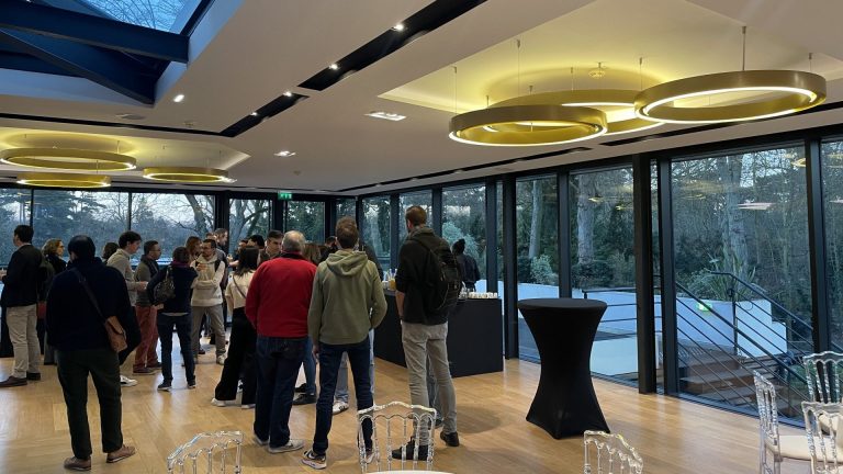 3DS Outscale annual conference participants gathered around high tables in the glass pavilion of the Pavillon Royal