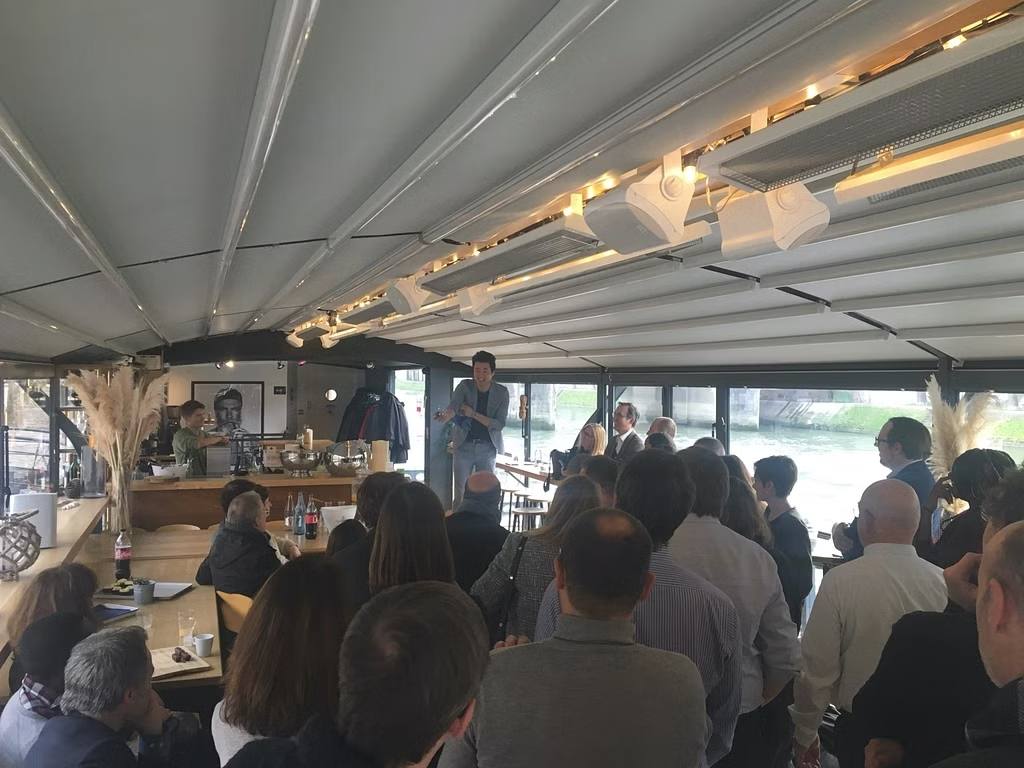 Collaborateurs de la SNCF assis sous la toile d'une péniche privatisée en bord de Seine, face à un intervenant, pendant leur journée d'étude organisée par Weevup