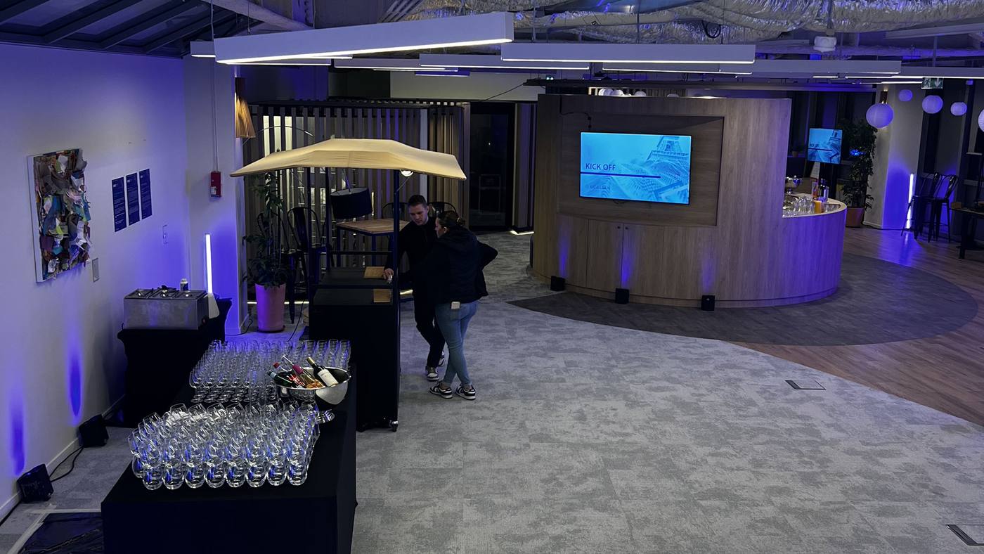 Espace de réception aménagé par Weevup dans les locaux de Scalian à Neuilly pour son kick-off : verres alignés sur un buffet, éclairage bleu et écran affichant « Kick off »