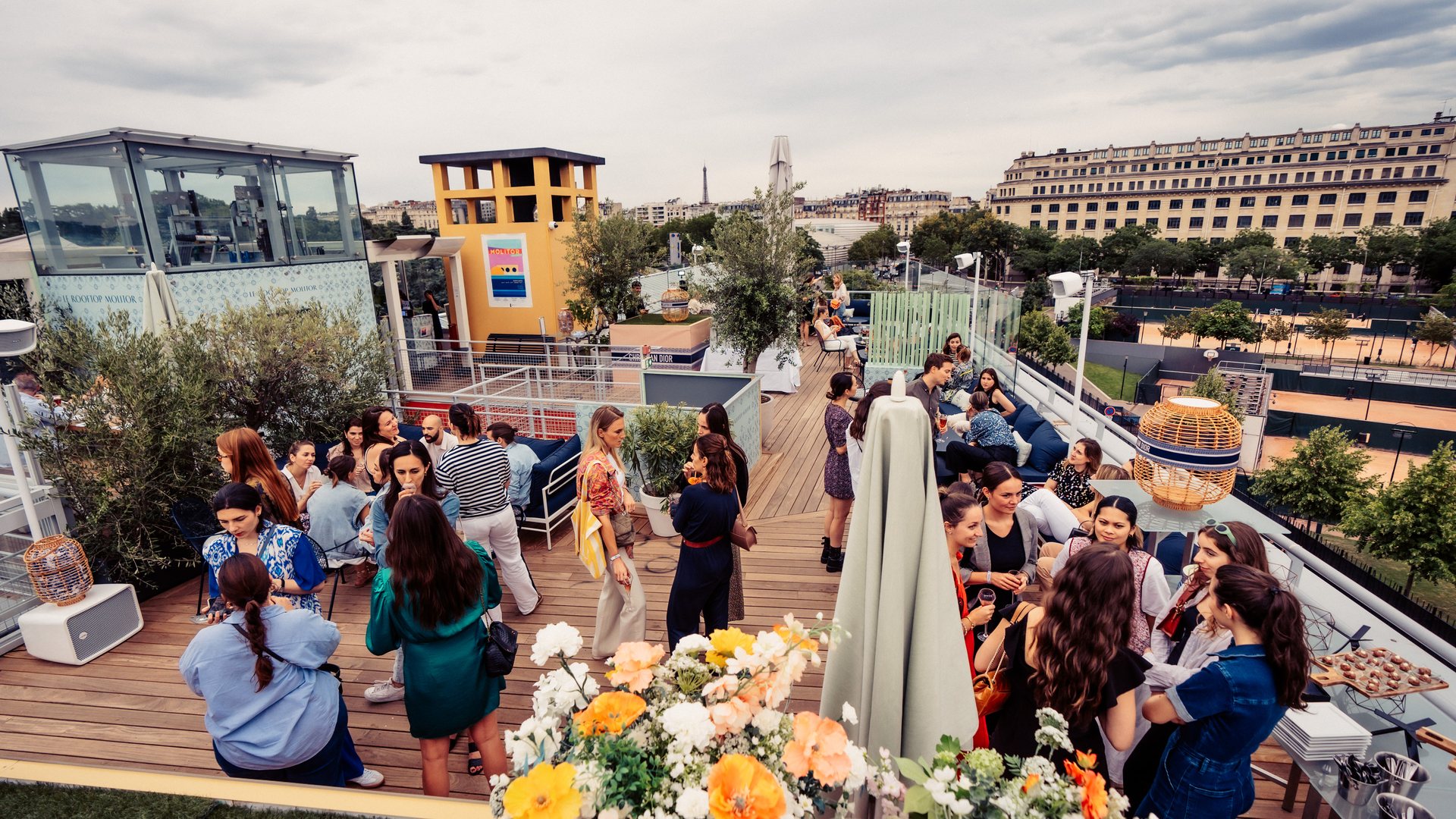 Cocktail d'entreprise sur un rooftop fleuri avec vue sur les toits de Paris, lors de la cocktail party Dior organisée par Weevup