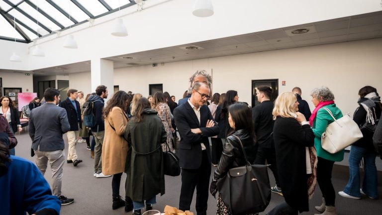 Participants du séminaire international SVR organisé par Weevup, manteaux sur le dos et sacs à l’épaule, réunis sous la verrière d’un atrium autour d’un café d’accueil