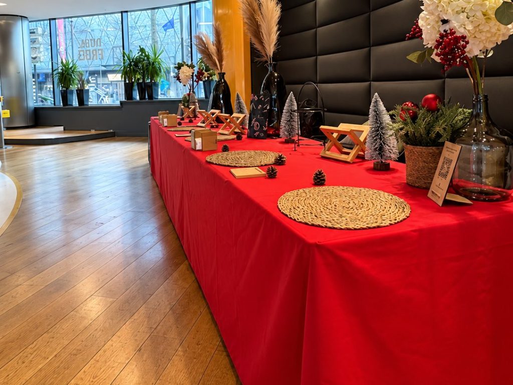 Table décorée pour Noël dans le hall du Pathé Beaugrenelle, avec sapins miniatures et objets en bois, pour l’après-midi de Noël de SSGA organisé par Weevup