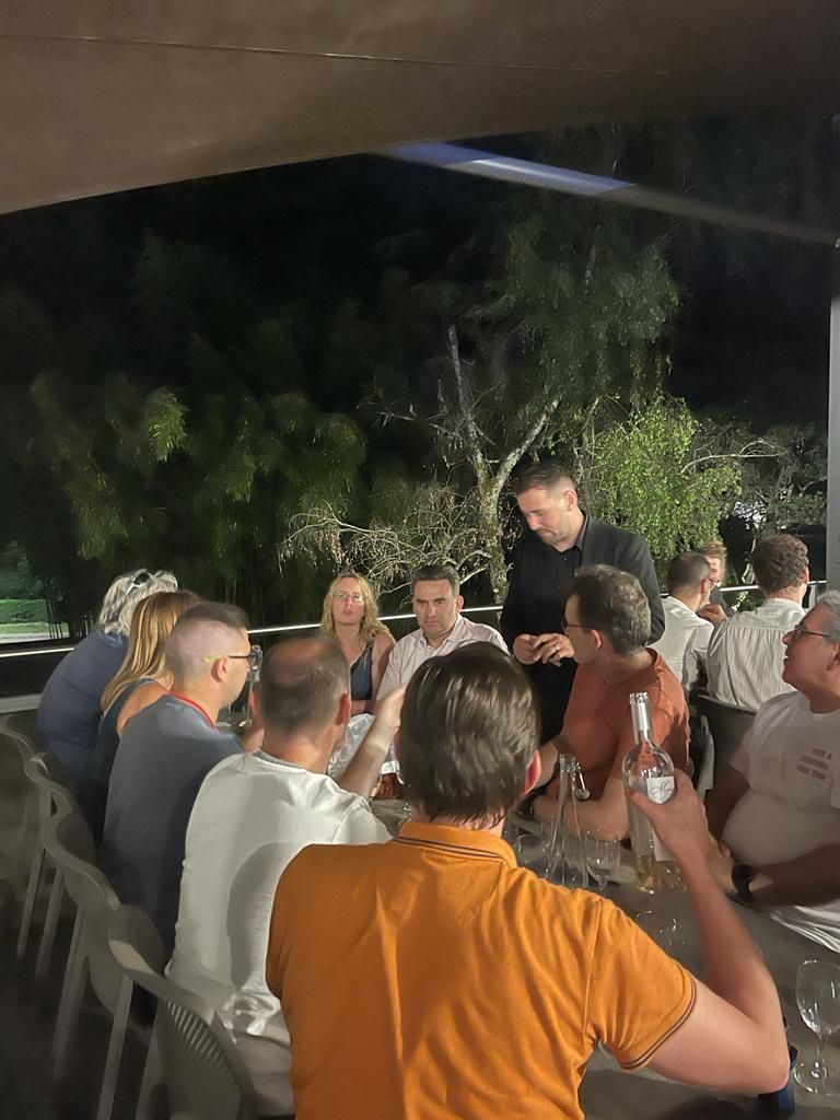 Dîner de nuit en terrasse à l’Hôtel Valpré, à Écully : un magicien présente un tour à une table de participants de Partecis