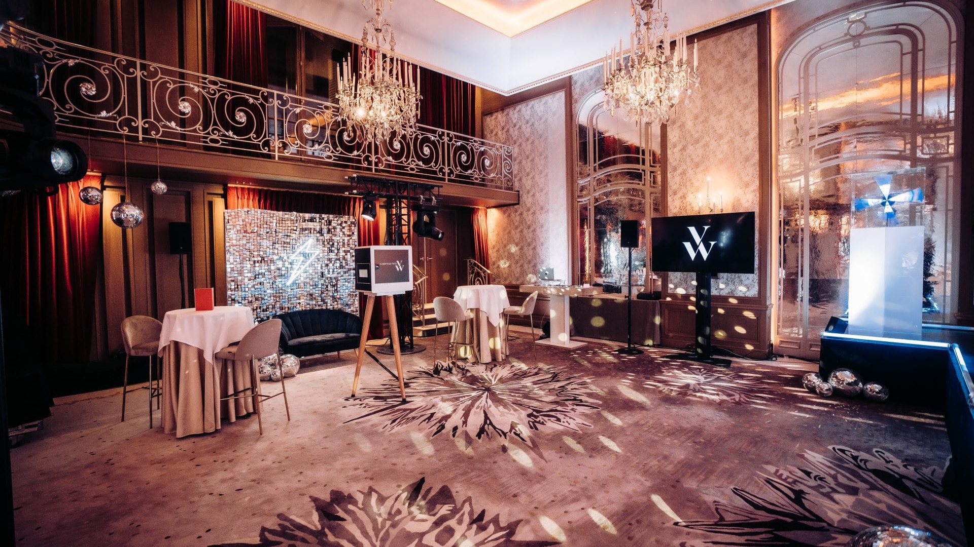 Salon à lustres aménagé par Weevup en plusieurs espaces : mange-debout nappés, mur de sequins, écran au logo de la marque et socle de présentation éclairé, pour la soirée de lancement de Vanessa Wu