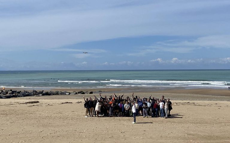 Participants de l’incentive de Libon réunis bras levés sur une plage du Pays basque
