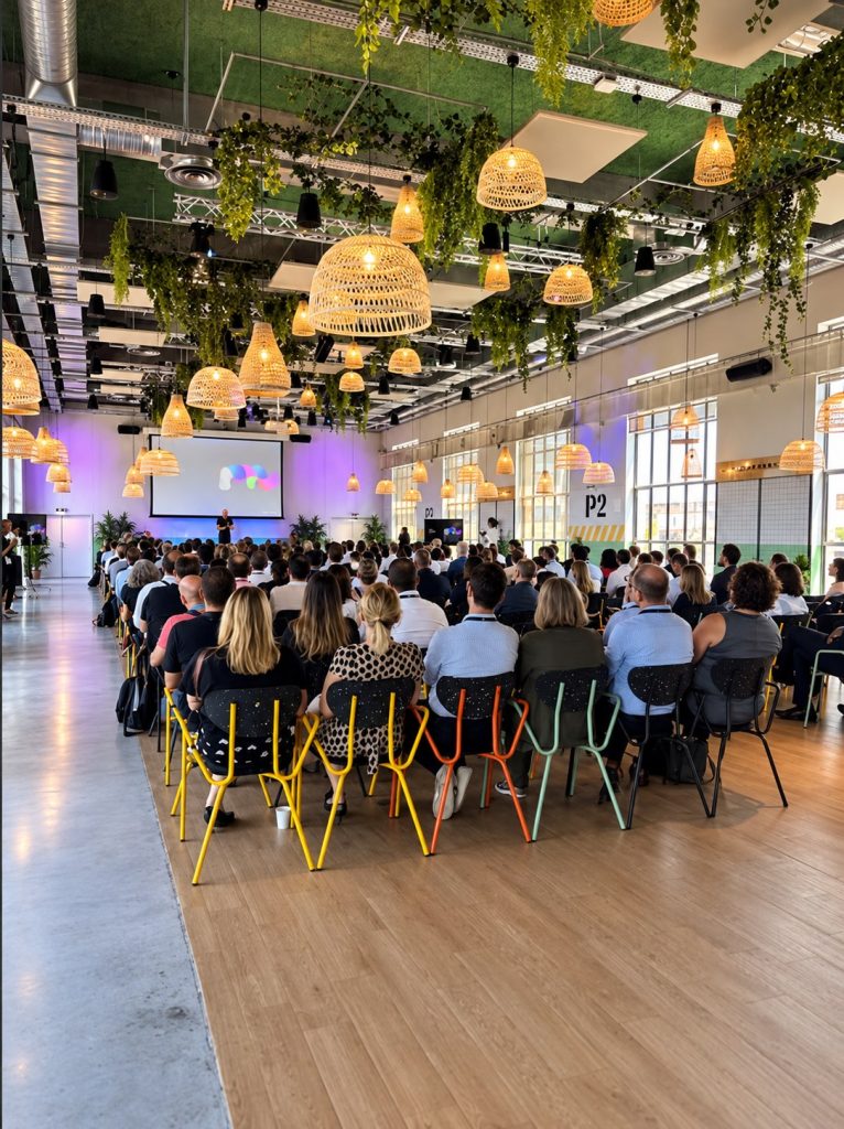 Vue de la salle plénière pendant SBS Connect Paris, avec 210 participants réunis dans un lieu végétalisé et lumineux.