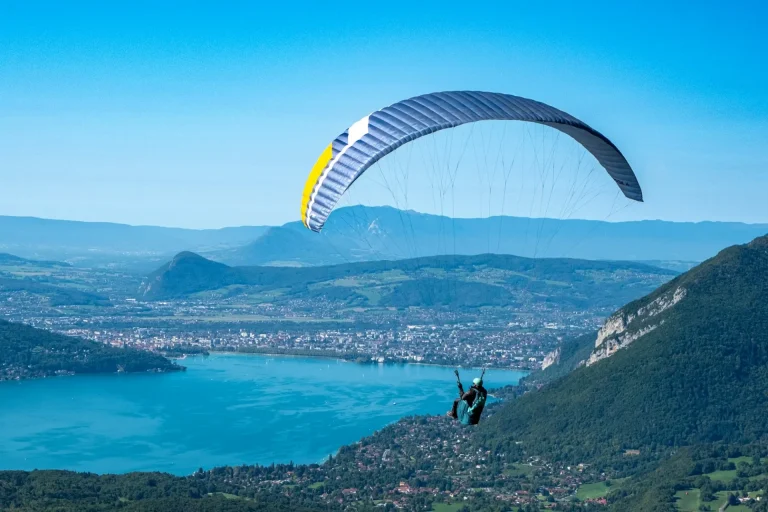 Un parapente au-dessus du lac d’Annecy, près du col de la Forclaz, avec la ville d’Annecy au loin