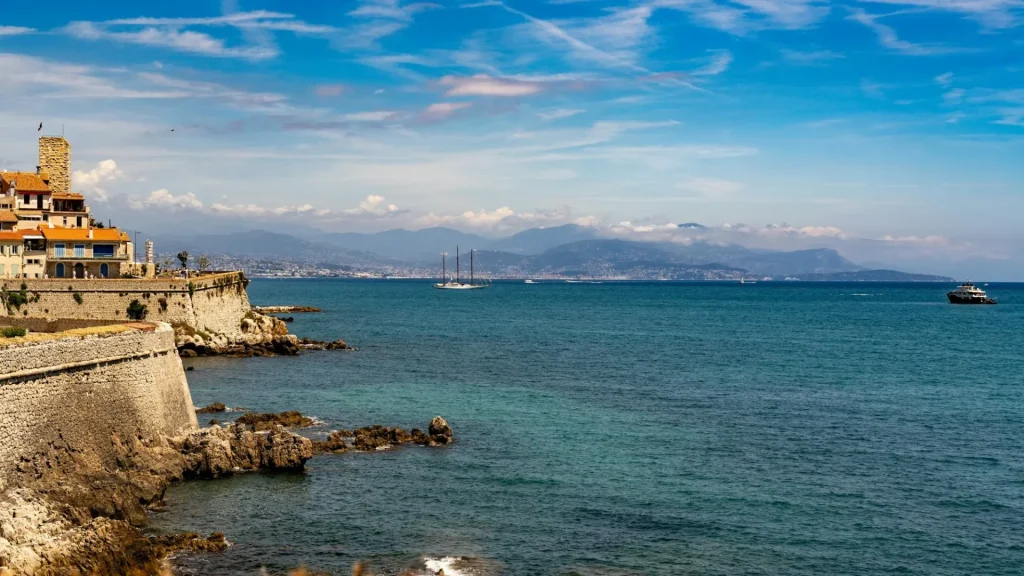 Les remparts de la vieille ville d’Antibes face à la Méditerranée, avec la côte et les montagnes au loin