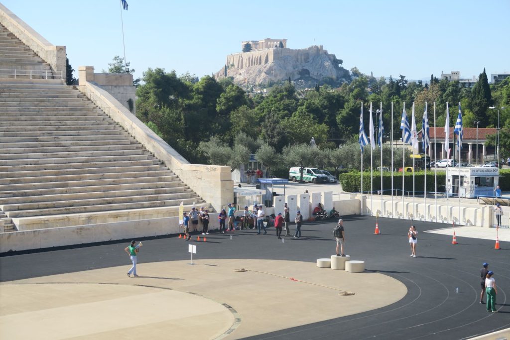 Stade panathénaïque d’Athènes pendant le team building de Bio-Rad, podium sur la piste, corde de tir à la corde au sol et Acropole en arrière-plan