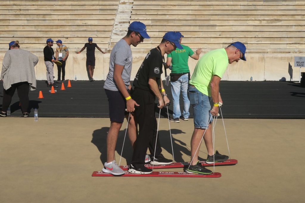 Course en équipe sur des planches de ski à poignées de corde, au stade panathénaïque d’Athènes, pendant le team building de Bio-Rad