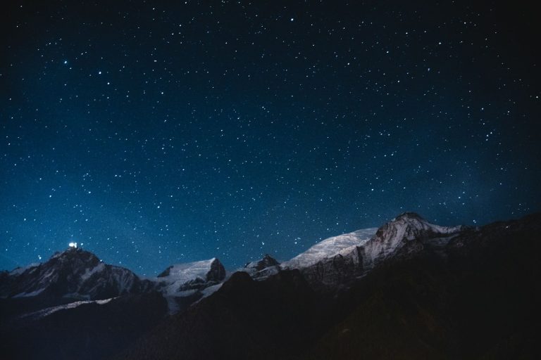 The snow-covered Aiguille du Midi under a starry sky, seen from Les Houches, in the Chamonix valley