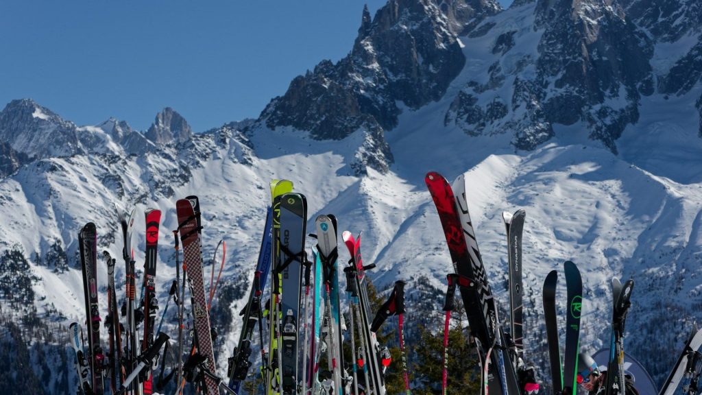 Skis plantés dans la neige au pied des sommets de la vallée de Chamonix