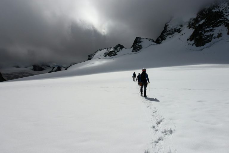 Marcheurs en file dans la neige fraîche d’un plateau enneigé, sous l’Aiguille du Midi, dans la vallée de Chamonix