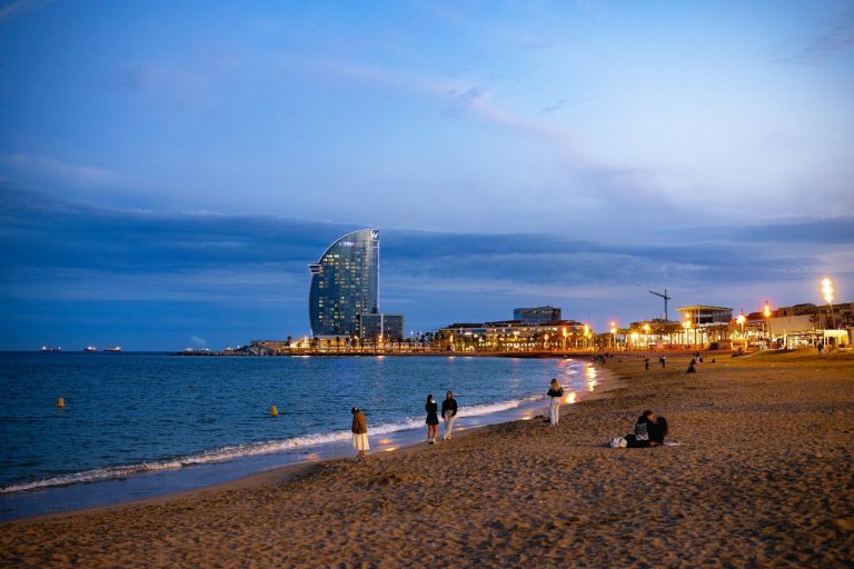 Plage de la Barceloneta au crépuscule, avec l’hôtel W Barcelona en forme de voile, sur le front de mer de Barcelone
