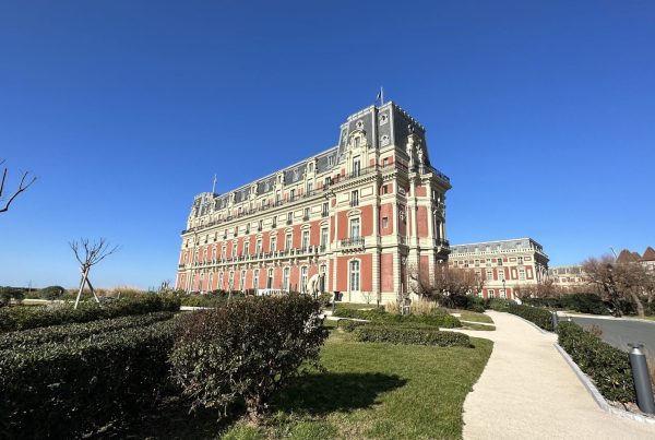 Façade en brique rouge et pierre d'un hôtel de charme aux allures de château, bordé de jardins, privatisé à Biarritz pour le séminaire résidentiel Husqvarna organisé par Weevup