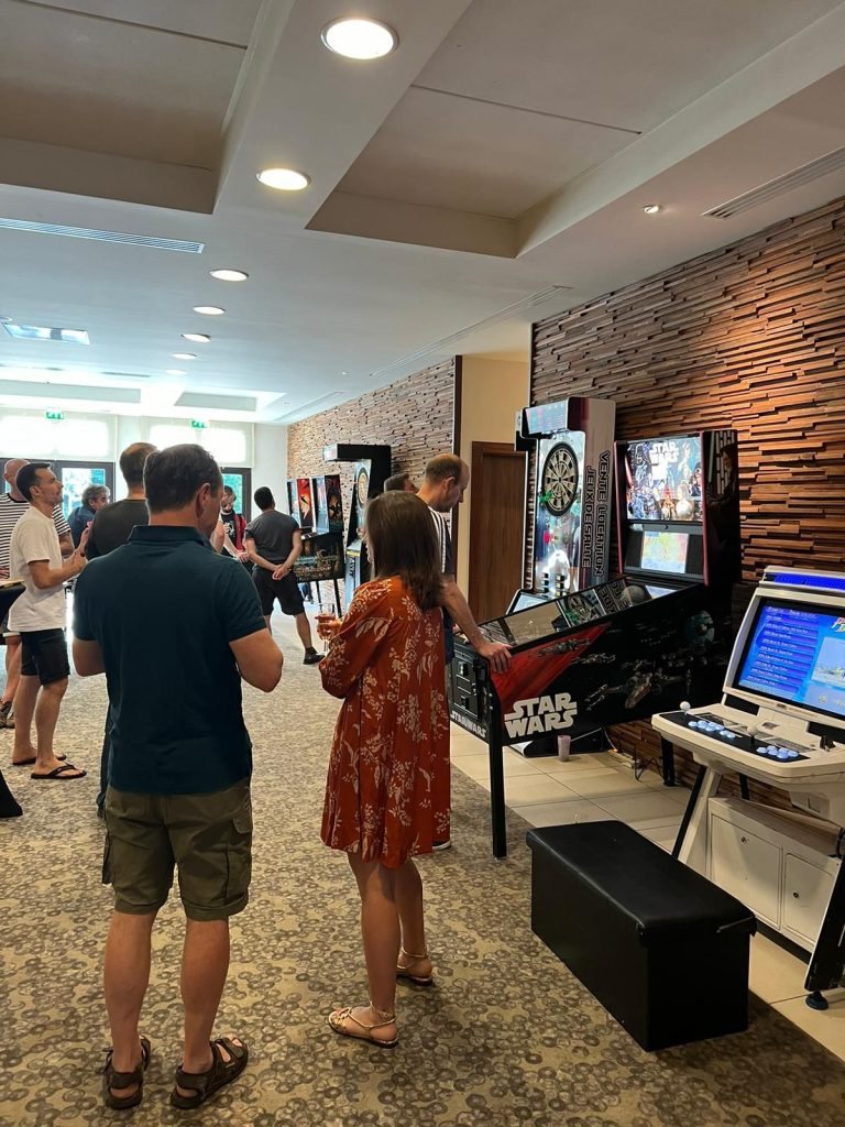 Flippers, fléchettes électroniques et borne d’arcade installés dans le foyer de l’hôtel pour la soirée jeux du séminaire de Partecis
