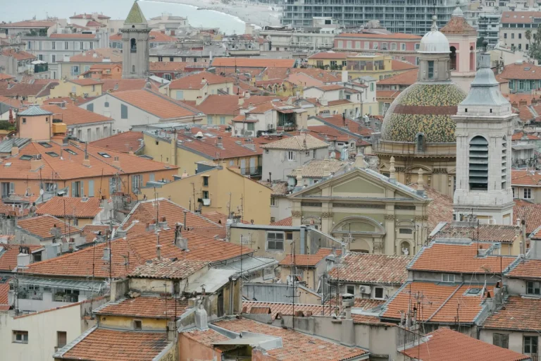 Les toits de tuiles du Vieux Nice, ses clochers et ses dômes, avec la mer au loin