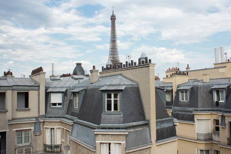 Les toits de Paris et la tour Eiffel vus depuis un immeuble haussmannien