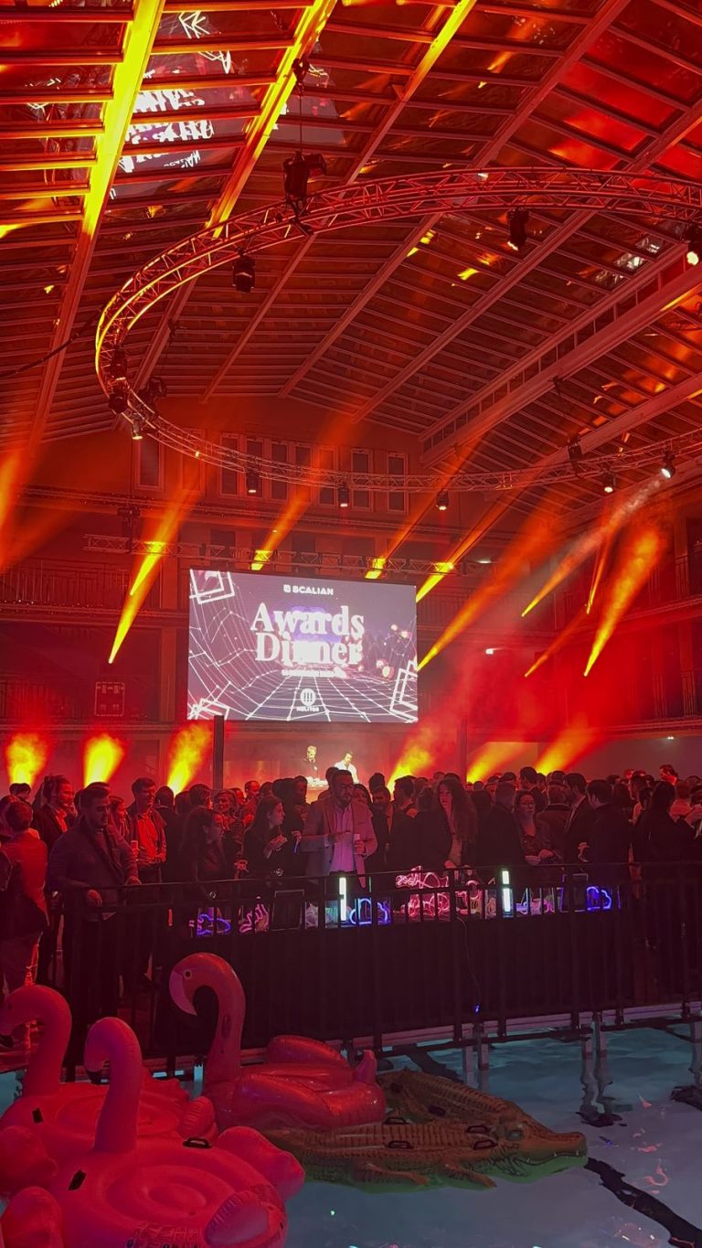 Invités de la soirée awards de Scalian réunis sur le bassin recouvert du Molitor, à Paris, sous des faisceaux de lumière orange
