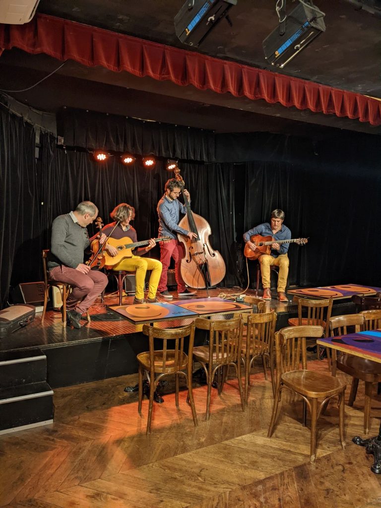 Quartet acoustique (violon, deux guitares et contrebasse) jouant sur la scène du Complexe du Rire, en début de soirée d’entreprise de Tyredating à Lyon