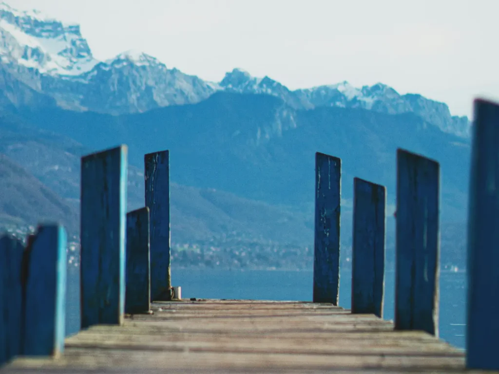 Un ponton en bois sur le lac d’Annecy, face aux montagnes enneigées