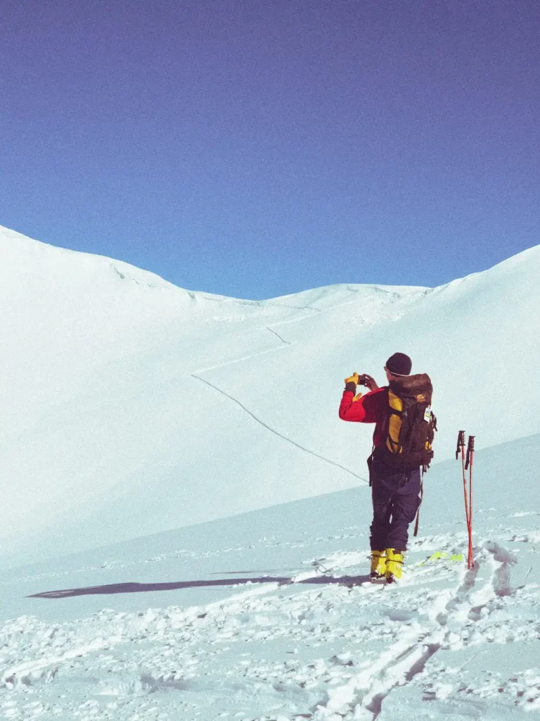 Un skieur en veste rouge sur les pentes enneigées de Chamrousse, dans la chaîne de Belledonne