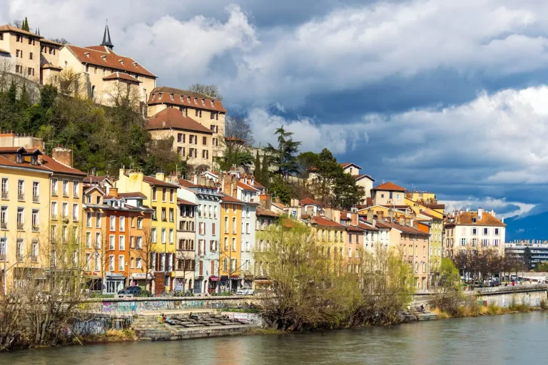 Façades colorées alignées le long des quais de l’Isère, au pied de la colline de la Bastille, à Grenoble