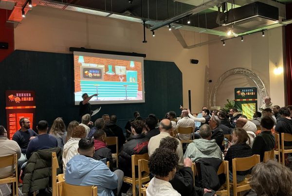 Participants d'ELO ÉNERGIE réunis face à un animateur et à un grand écran de jeu, pendant le team building organisé par Weevup à l'EKLO Hôtel de Nantes