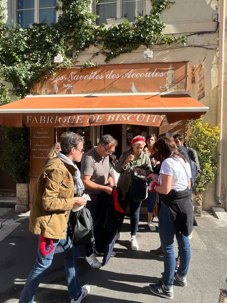 Participants du rallye Swiss Life, tablette en main, devant une fabrique de navettes marseillaises, étape dégustation du dernier jour du séminaire