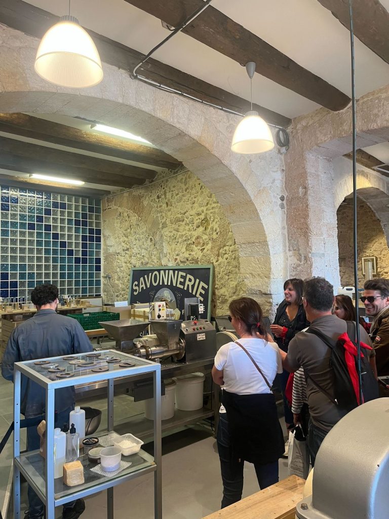 Participants du séminaire Swiss Life dans une savonnerie de Marseille, devant une machine de fabrication du savon, étape création de savon du rallye