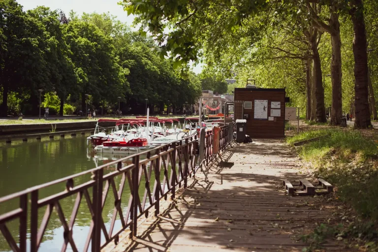 Petits bateaux amarrés le long d’un quai bordé d’arbres, au bord de la Deûle, à Lille